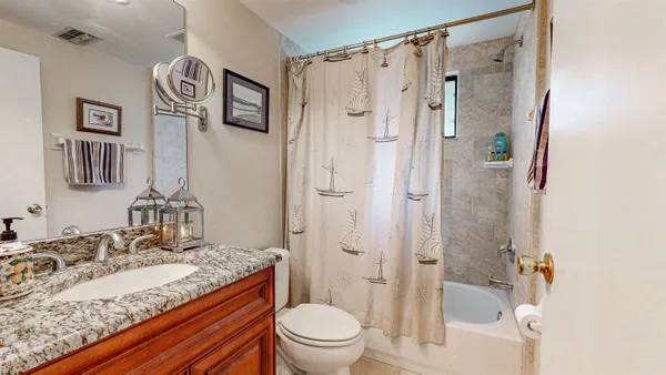 a bathroom with a granite countertop sink toilet and shower