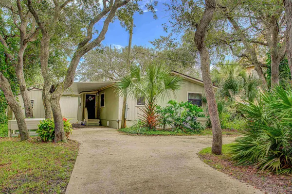 a front view of a house with a yard and tree s