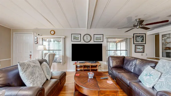 a living room with furniture a window and a flat screen tv