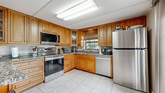 a kitchen with stainless steel appliances granite countertop a refrigerator stove top oven and sink