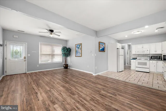a view of empty room with wooden floor and windows