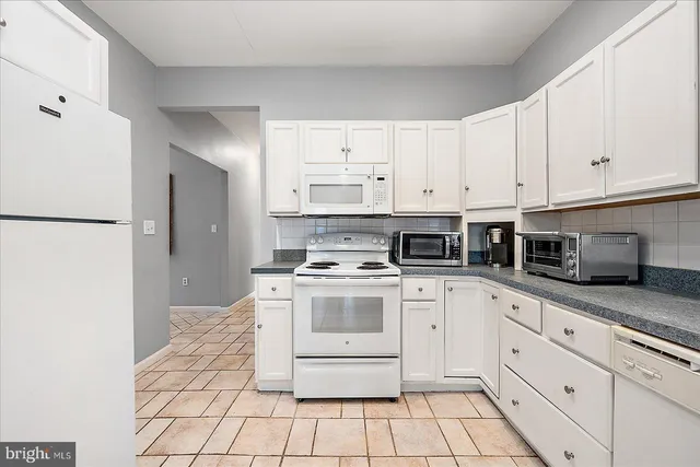 a kitchen with cabinets stainless steel appliances and a counter space