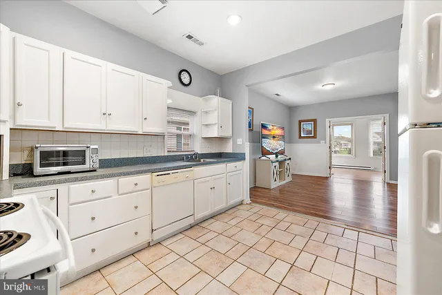 a large white kitchen with cabinets