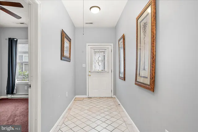 a view of a hallway with windows and chandelier