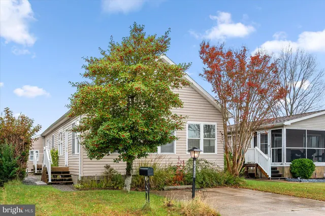 a front view of a house with garden and plants