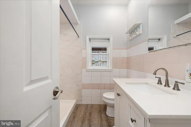 a bathroom with a sink toilet and window