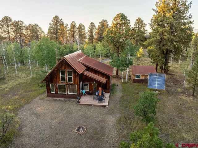 an outdoor view of house with backyard and trees around