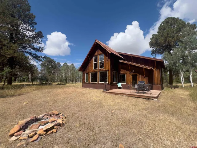 a view of a house with backyard and sitting area