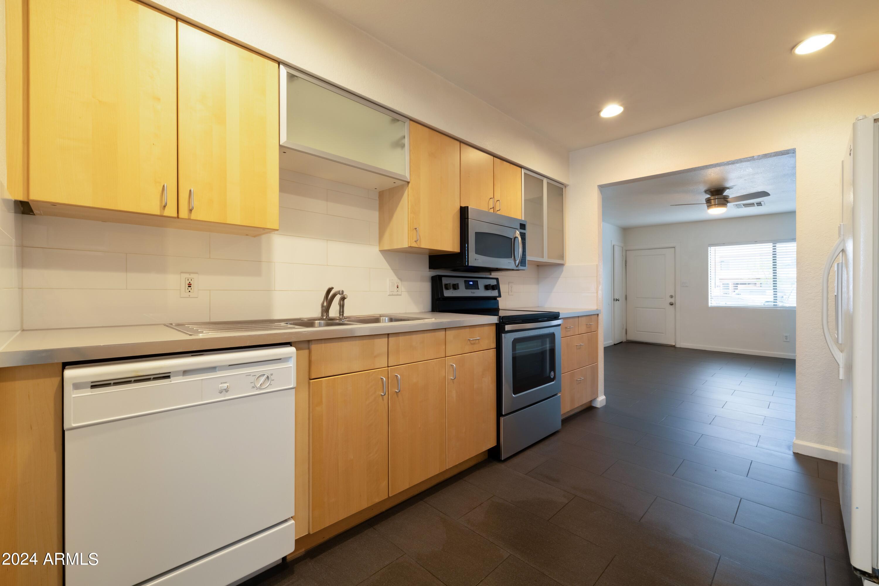 3034 North 35th Street Phoenix, AZ 85018 - Photo 18 of 37 a kitchen with white cabinets and white appliances