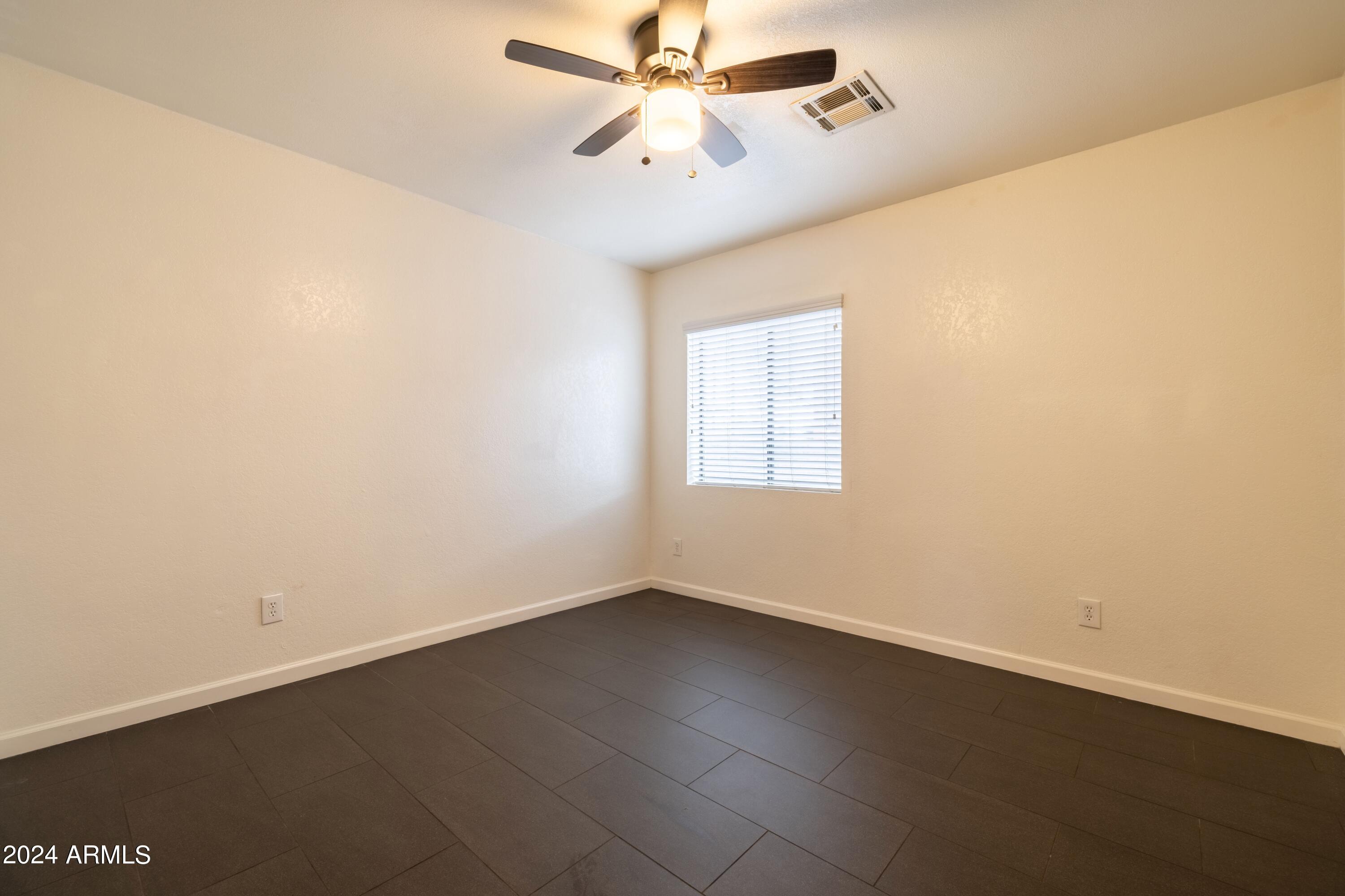 3034 North 35th Street Phoenix, AZ 85018 - Photo 22 of 37 an empty room with a window and a ceiling fan
