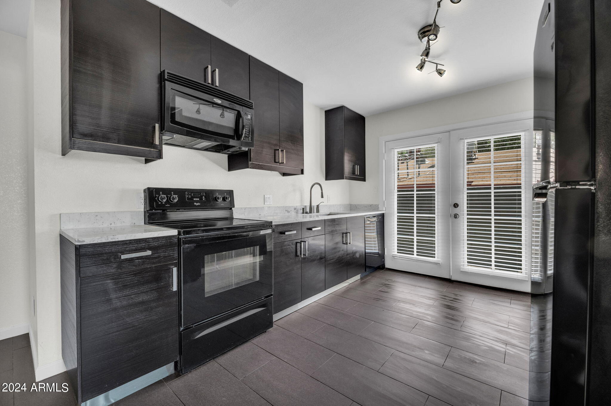3034 North 35th Street Phoenix, AZ 85018 - Photo 6 of 37 a kitchen with stainless steel appliances a sink stove and wooden floor