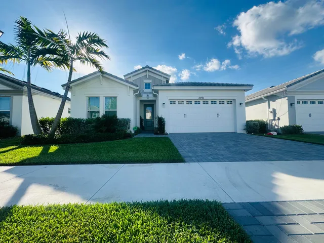 a view of a house with a yard and potted plants