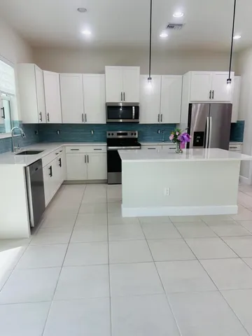 a large white kitchen with cabinets