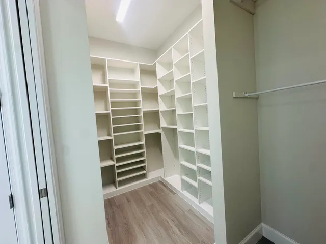 a view of walk in closet with empty racks