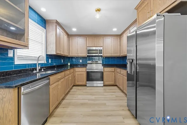 a kitchen with kitchen island granite countertop stainless steel appliances and cabinets