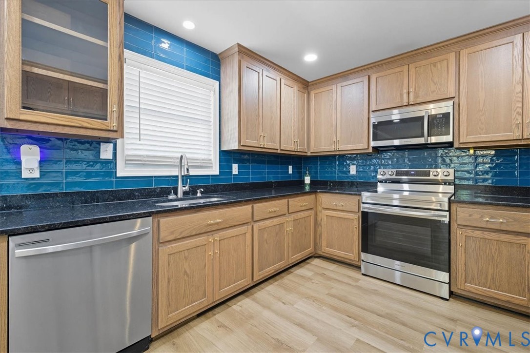 1005 West Main Street Waverly, VA 23890 - Photo 19 of 32 a kitchen with granite countertop cabinets stainless steel appliances a sink and a window