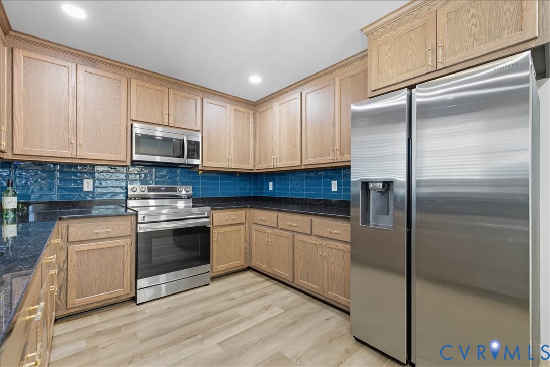 1005 West Main Street Waverly, VA 23890 - Photo 20 of 32 a kitchen with stainless steel appliances granite countertop a stove a sink and a refrigerator