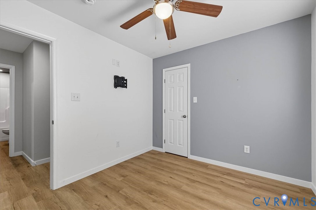 1005 West Main Street Waverly, VA 23890 - Photo 22 of 32 an empty room with wooden floor and ceiling fan