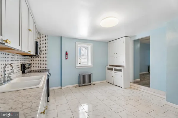 a kitchen with granite countertop a sink cabinets and stainless steel appliances