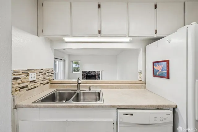 a kitchen with a sink a stove and white cabinets