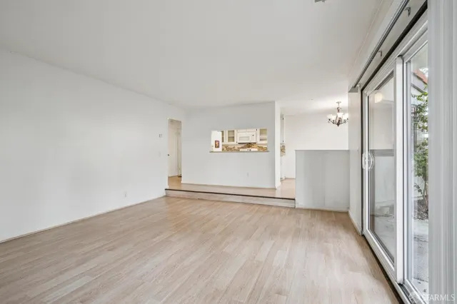 a view of a big room with wooden floor and windows