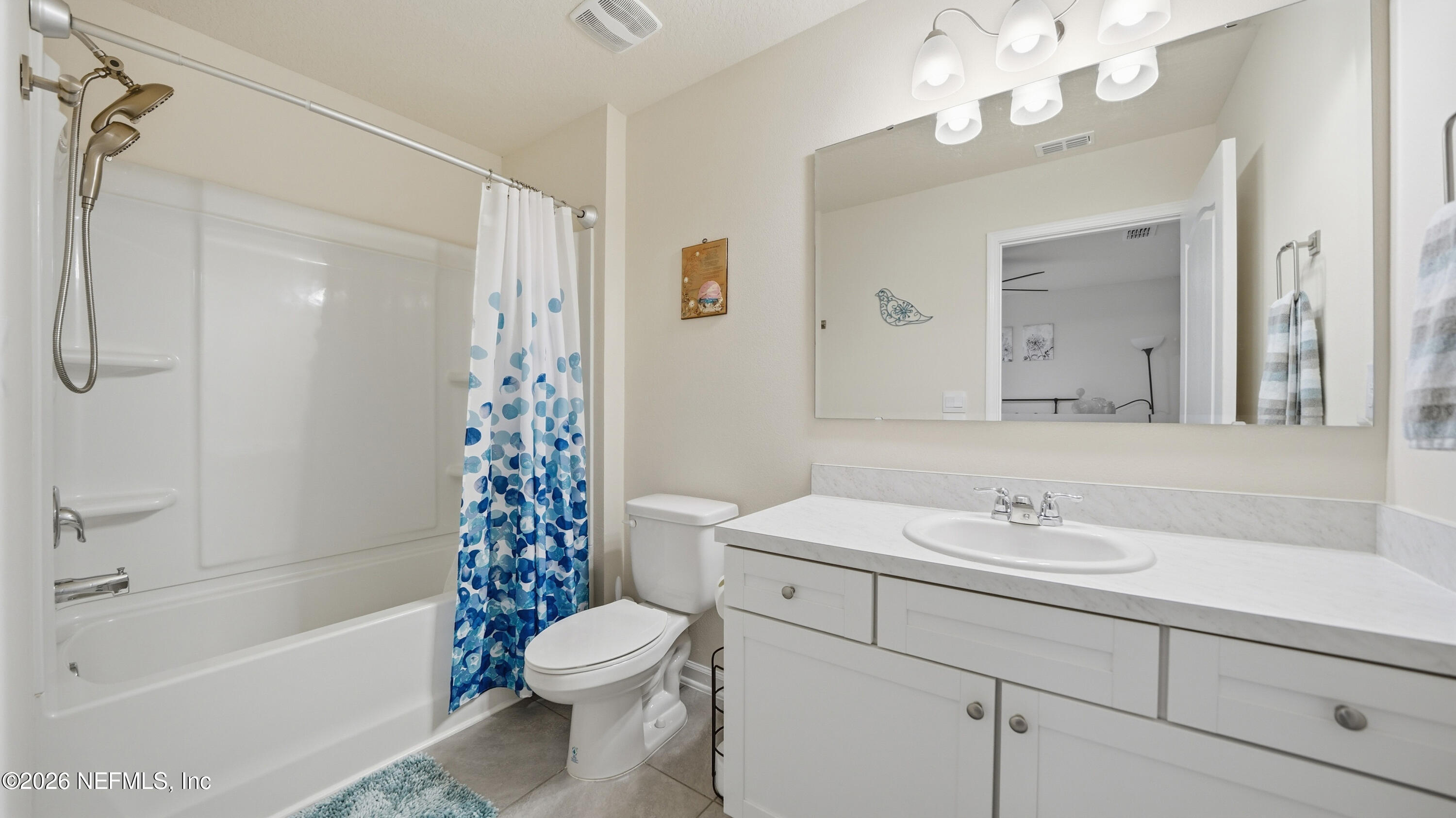 172 Redbud Road Palm Coast, FL 32137 - Photo 29 of 43 a bathroom with a sink a toilet a mirror a vanity a bathtub and shower