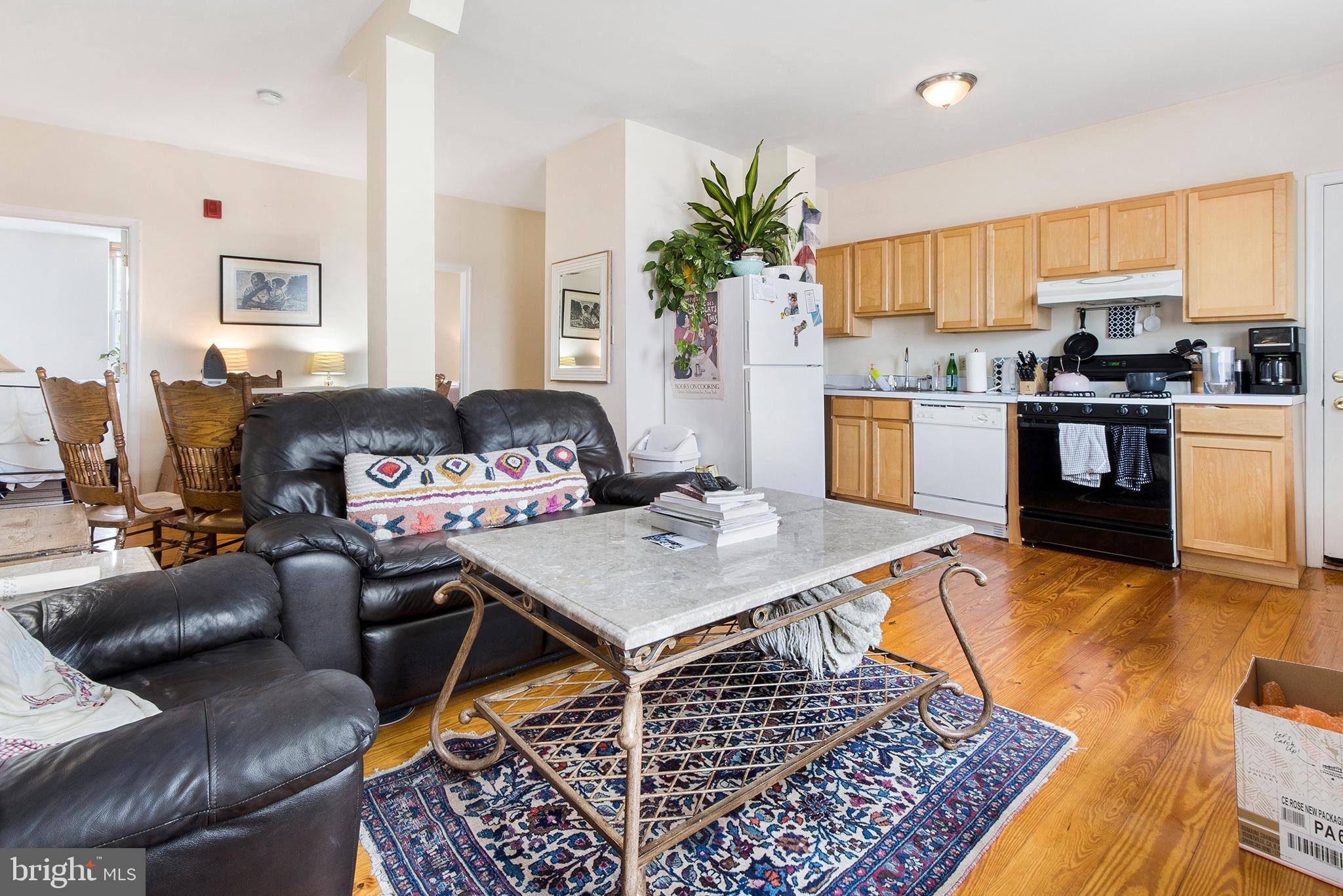 a living room with stainless steel appliances furniture stove and a kitchen view