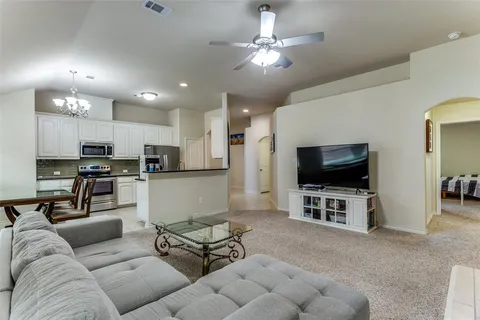 a kitchen with stainless steel appliances granite countertop a table chairs and a refrigerator