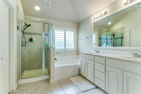 a en suite bathroom with a double vanity sink and a mirror