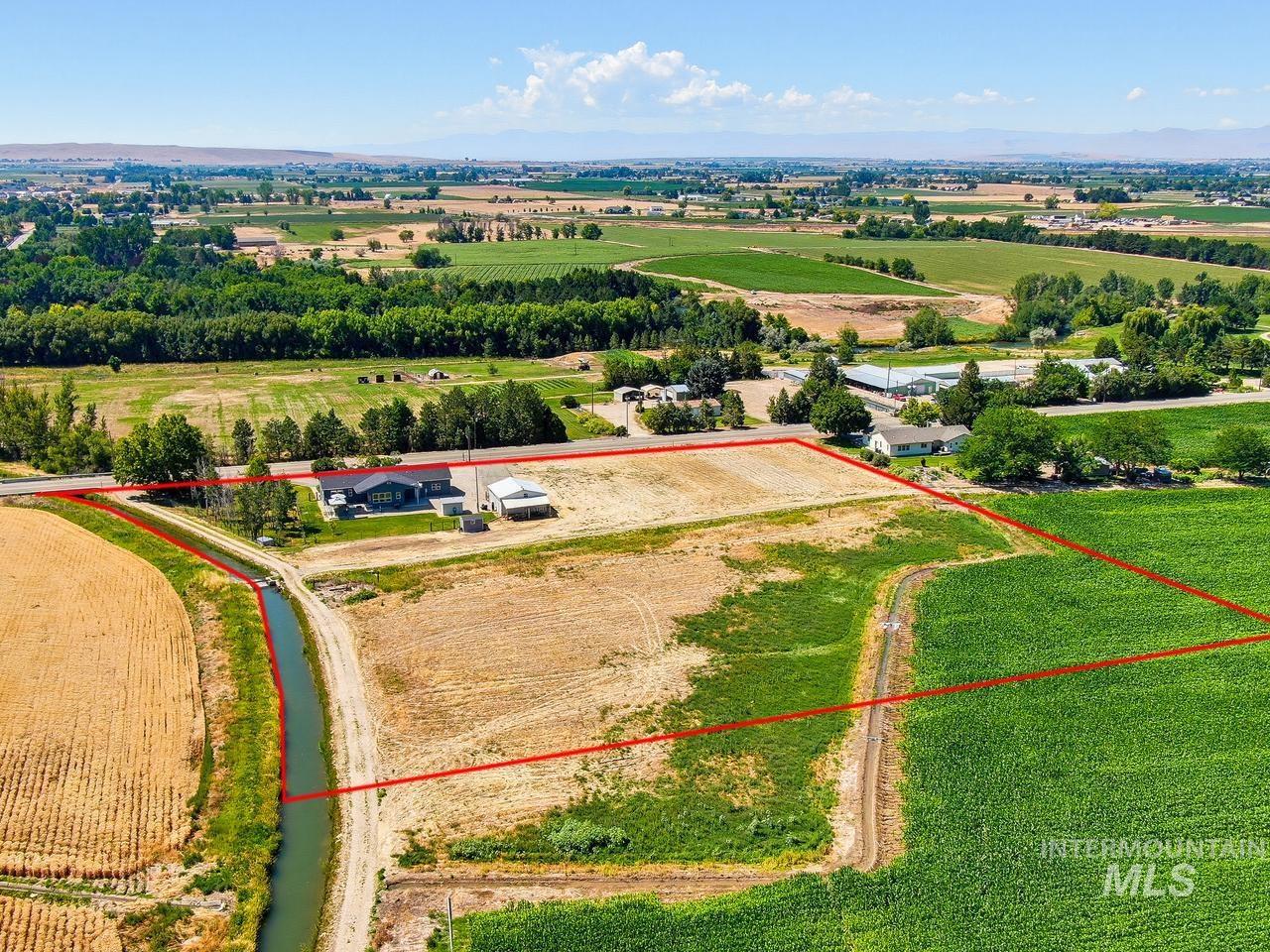4950 West Columbia Road Nampa, ID 83687 - Photo 47 of 50 Expansive agricultural land featuring a water canal and surrounding fields