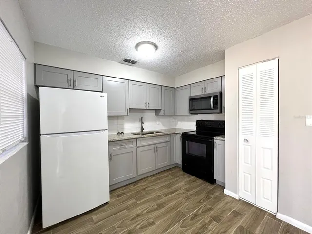 a kitchen with a refrigerator stove and sink