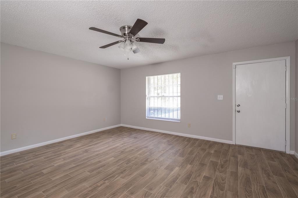 6216 Southwest 10th Place, Unit B Gainesville, FL 32607 - Photo 14 of 24 a view of a big room with wooden floor closet and windows