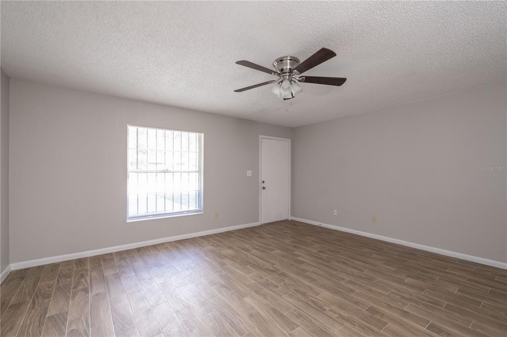 6216 Southwest 10th Place, Unit B Gainesville, FL 32607 - Photo 15 of 24 a view of empty room with wooden floor and fan