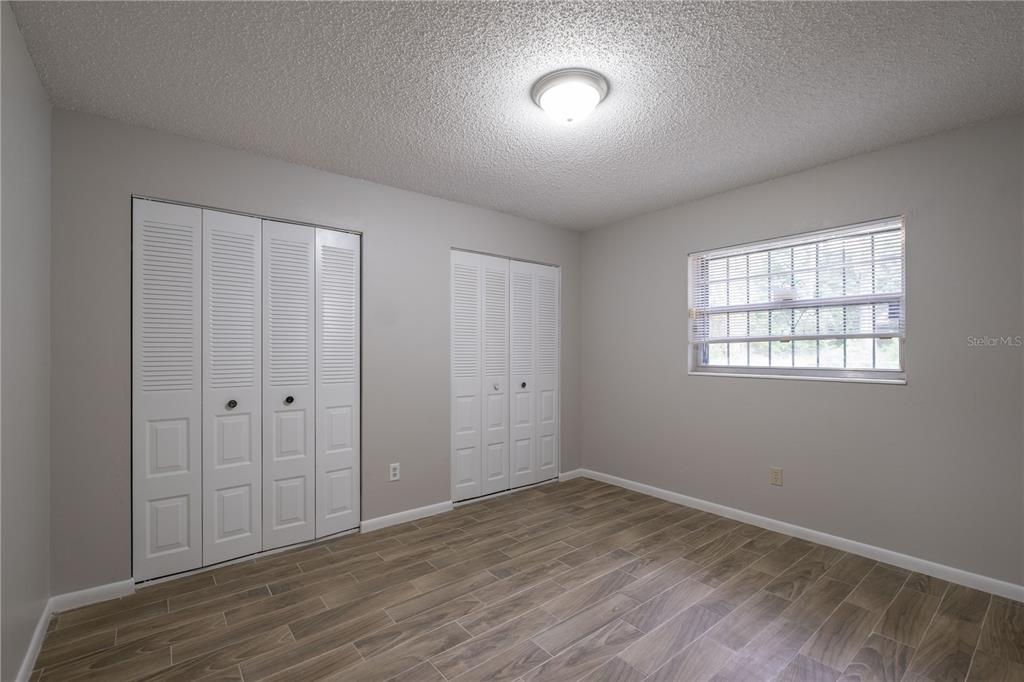 6216 Southwest 10th Place, Unit B Gainesville, FL 32607 - Photo 16 of 24 an empty room with wooden floor and windows