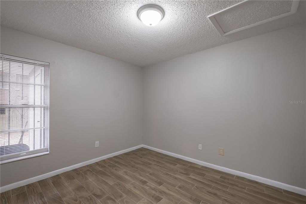 6216 Southwest 10th Place, Unit B Gainesville, FL 32607 - Photo 17 of 24 an empty room with wooden floor and windows