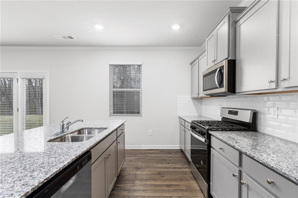 5370 Swan Lane Powder Springs, GA 30127 - Photo 11 of 54 a kitchen with granite countertop stainless steel appliances a sink stove top oven and cabinets
