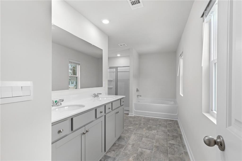 5370 Swan Lane Powder Springs, GA 30127 - Photo 23 of 54 a bathroom with a granite countertop sink a mirror and a bathtub