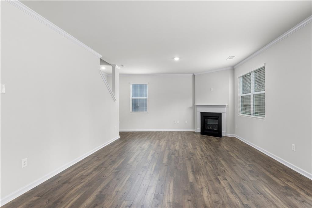5370 Swan Lane Powder Springs, GA 30127 - Photo 3 of 54 an empty room with wooden floor fireplace and windows