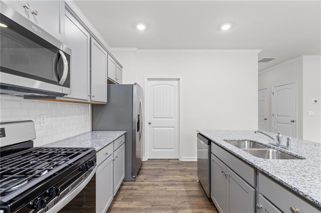 5370 Swan Lane Powder Springs, GA 30127 - Photo 4 of 54 a kitchen with stainless steel appliances granite countertop a sink stove and refrigerator