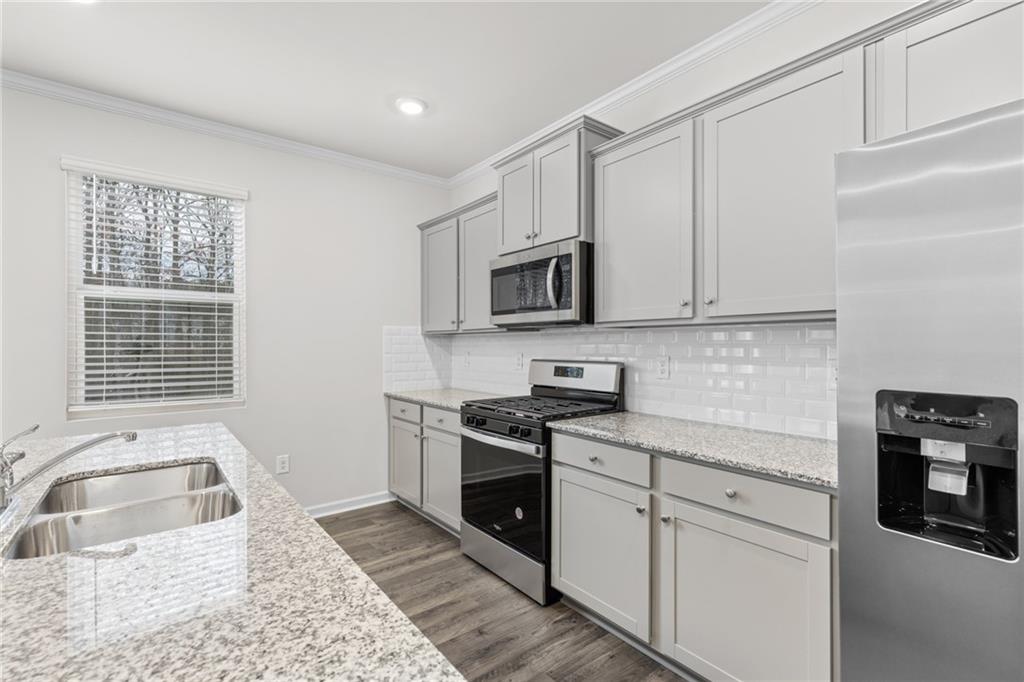 5370 Swan Lane Powder Springs, GA 30127 - Photo 6 of 54 a kitchen with stainless steel appliances granite countertop a stove a sink and a microwave