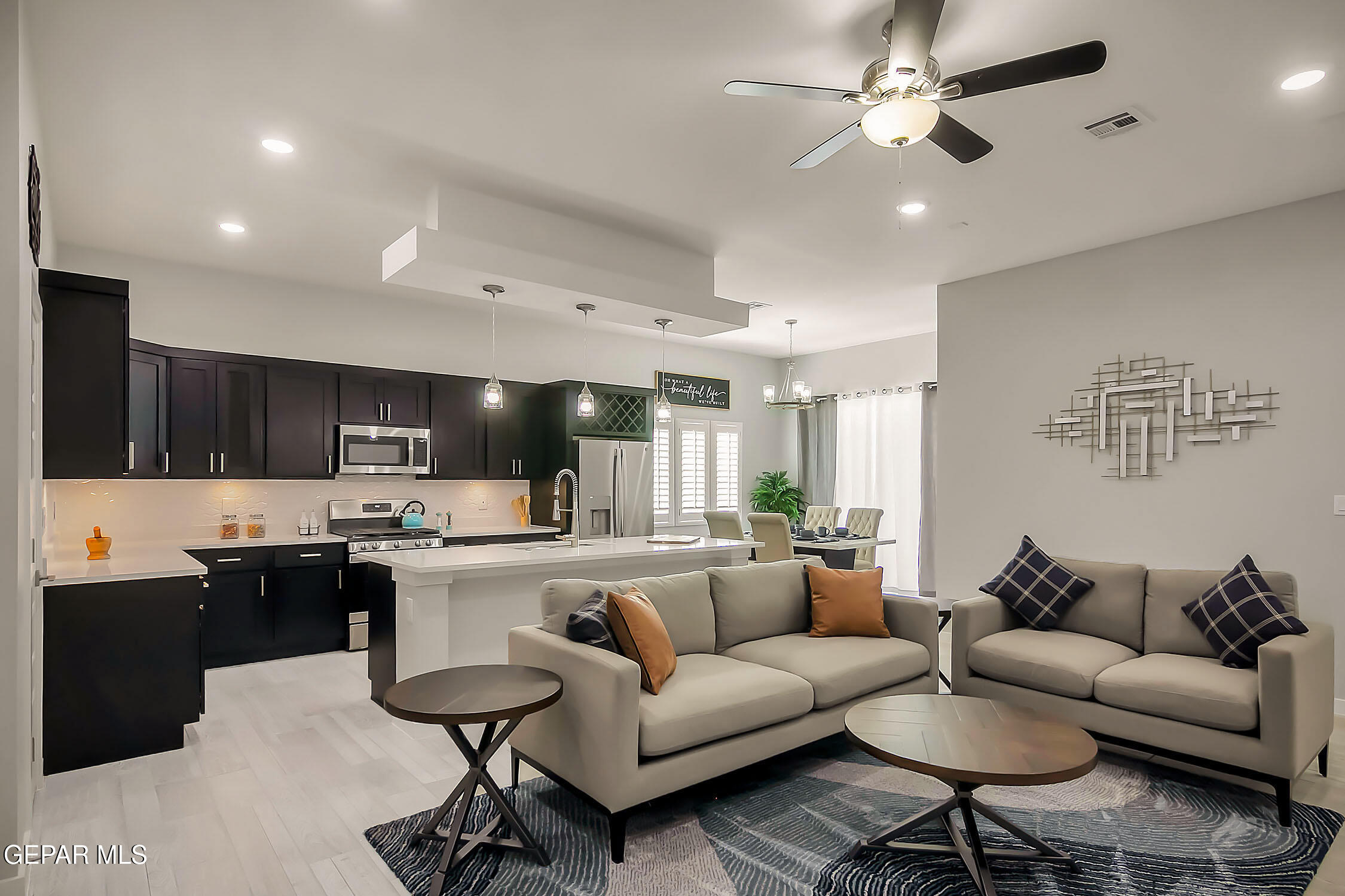 3853 Object Place El Paso, TX 79938 - Photo 16 of 31 a living room with stainless steel appliances kitchen island granite countertop a couch and a view of kitchen