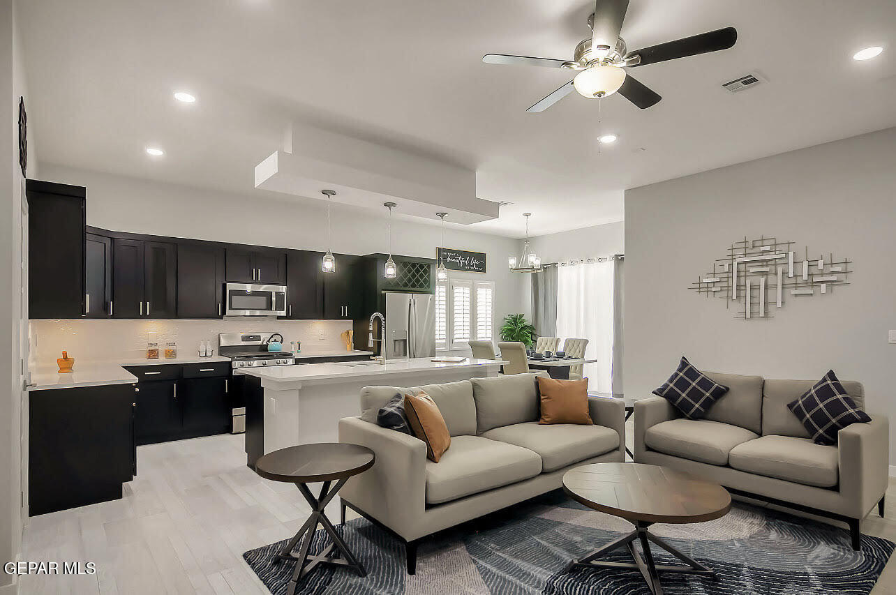 3853 Object Place El Paso, TX 79938 - Photo 4 of 31 a living room with stainless steel appliances kitchen island granite countertop a couch and a view of kitchen