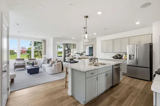 a kitchen with stainless steel appliances granite countertop a sink stove and wooden floor