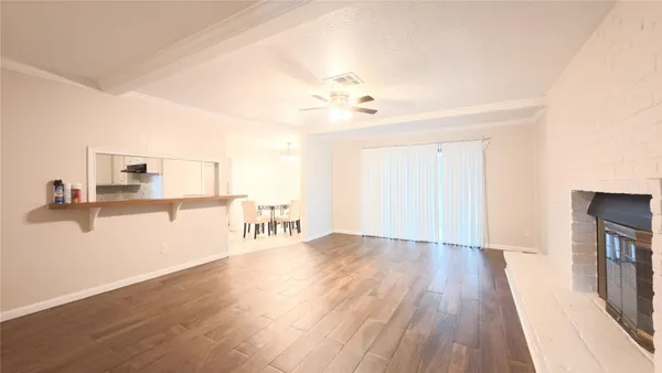 a view of a kitchen with wooden floor and a flat screen tv