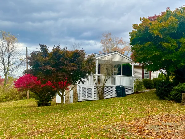 a front view of house with yard and trees in the background