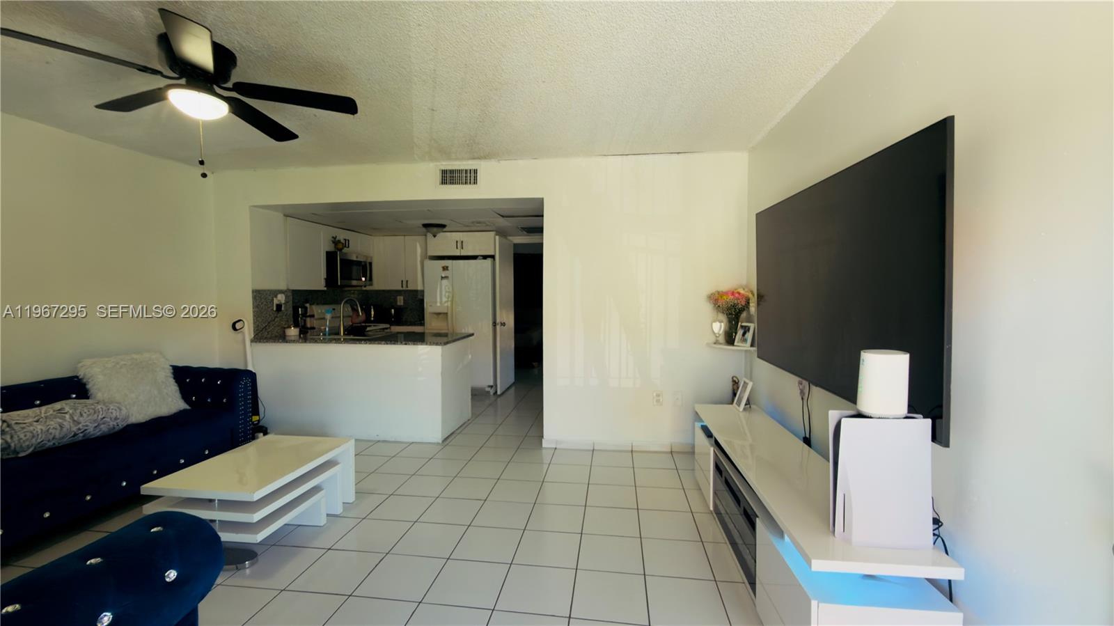 2170 West 60th Street, Unit 16205 Hialeah, FL 33016 - Photo 6 of 6 a living room with furniture and a flat screen tv