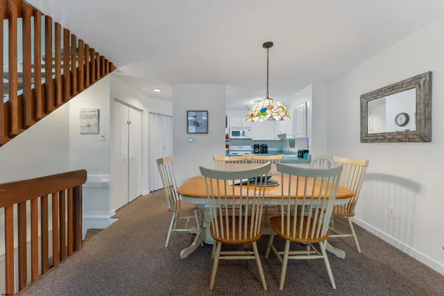 a dining room with furniture a chandelier and wooden floor