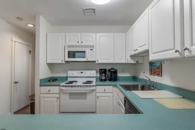 a kitchen with cabinets appliances a sink and a counter top space