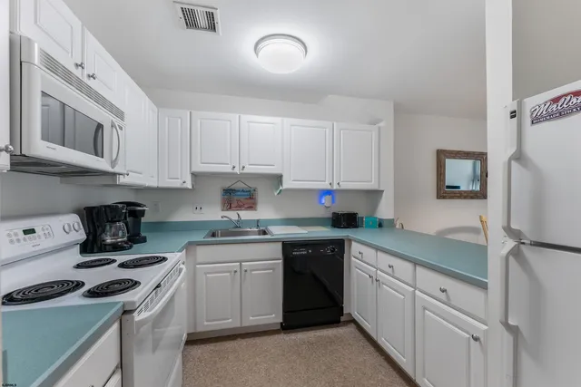 a kitchen with cabinets appliances a sink and a counter top space