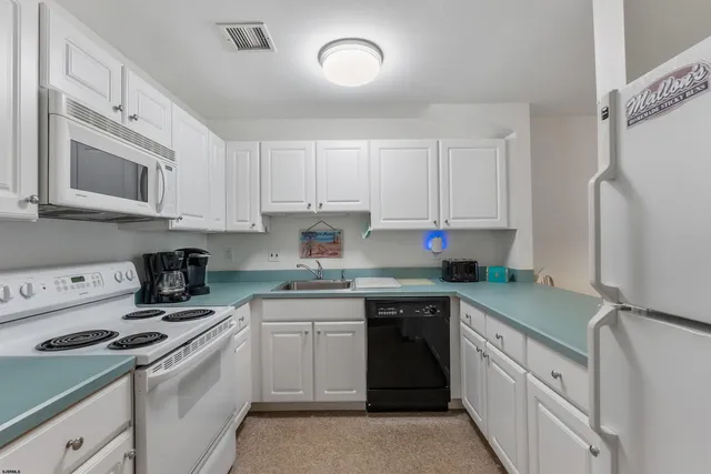 a kitchen with cabinets appliances a sink and a counter top space